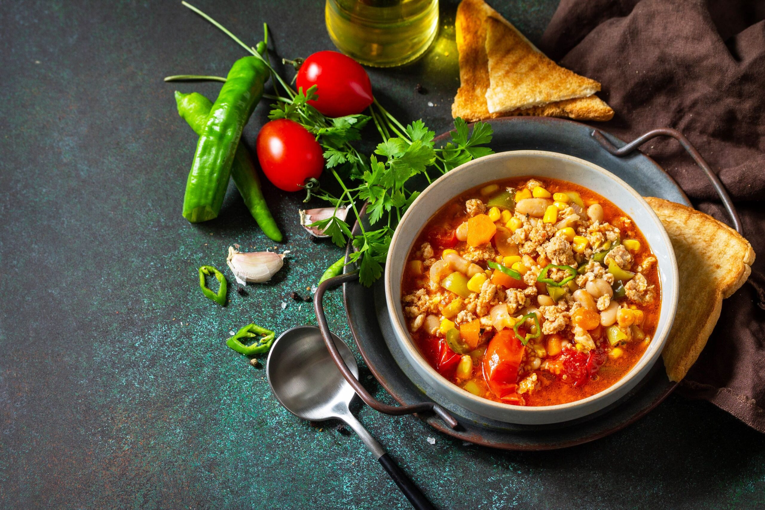 Traditional mexican food. Chili con carne, minced meat with vegetables on dark stone table. Copy space.